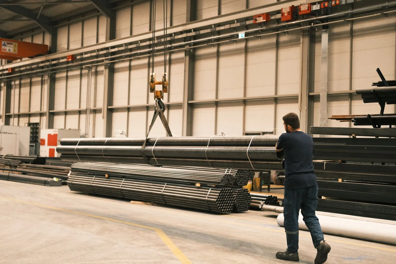 Worker guiding a pipe lift